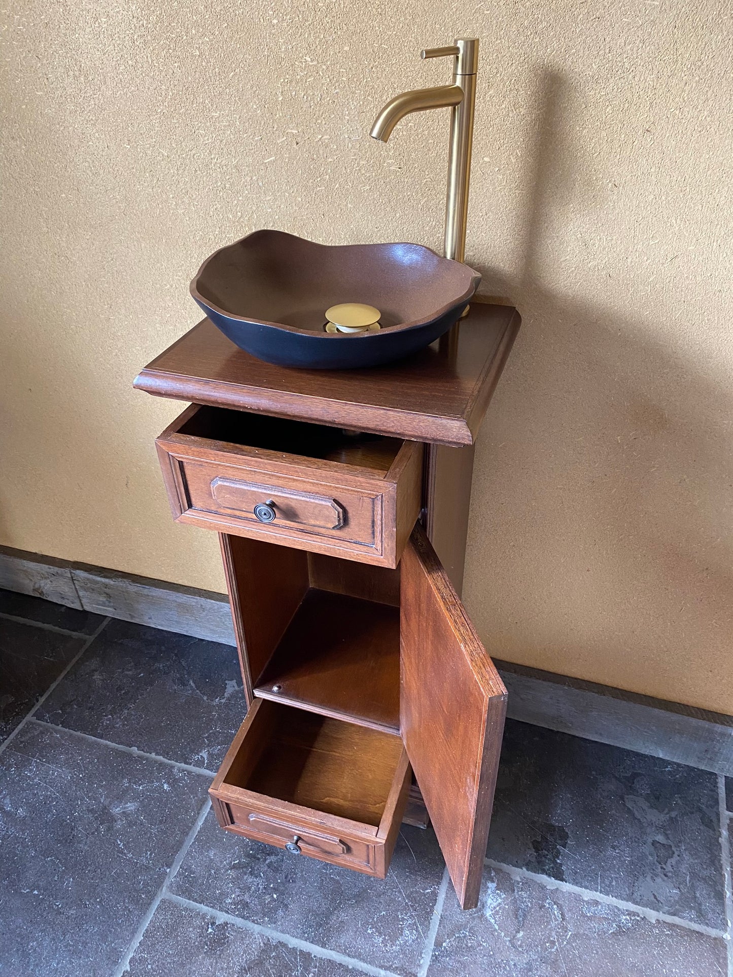 Ambachtelijk sanitair meubeltje met zwart/bruine keramische spoelbak en elegant kraantje
