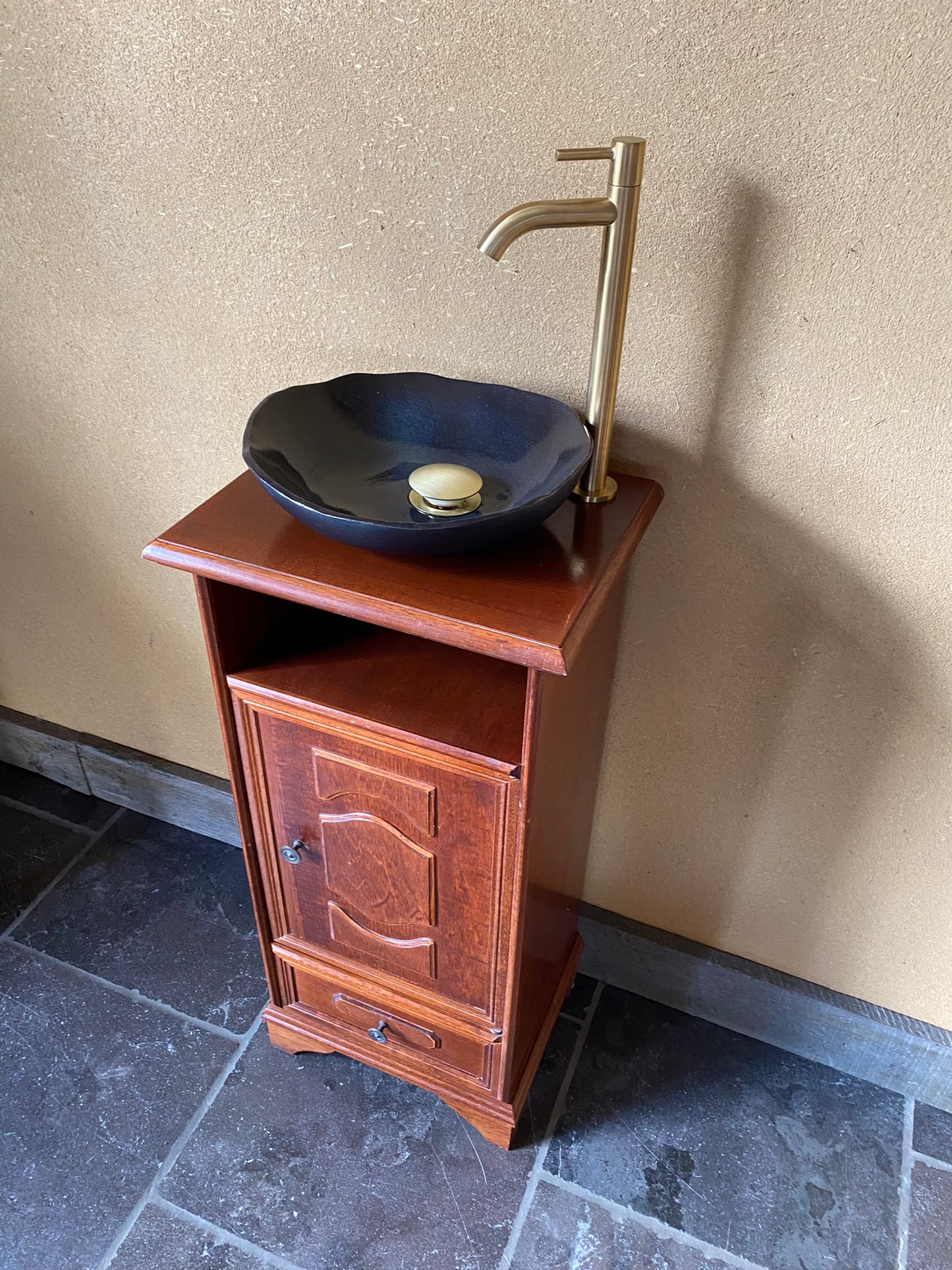 Ambachtelijk sanitair meubeltje met zwarte keramische spoelbak en elegant kraantje