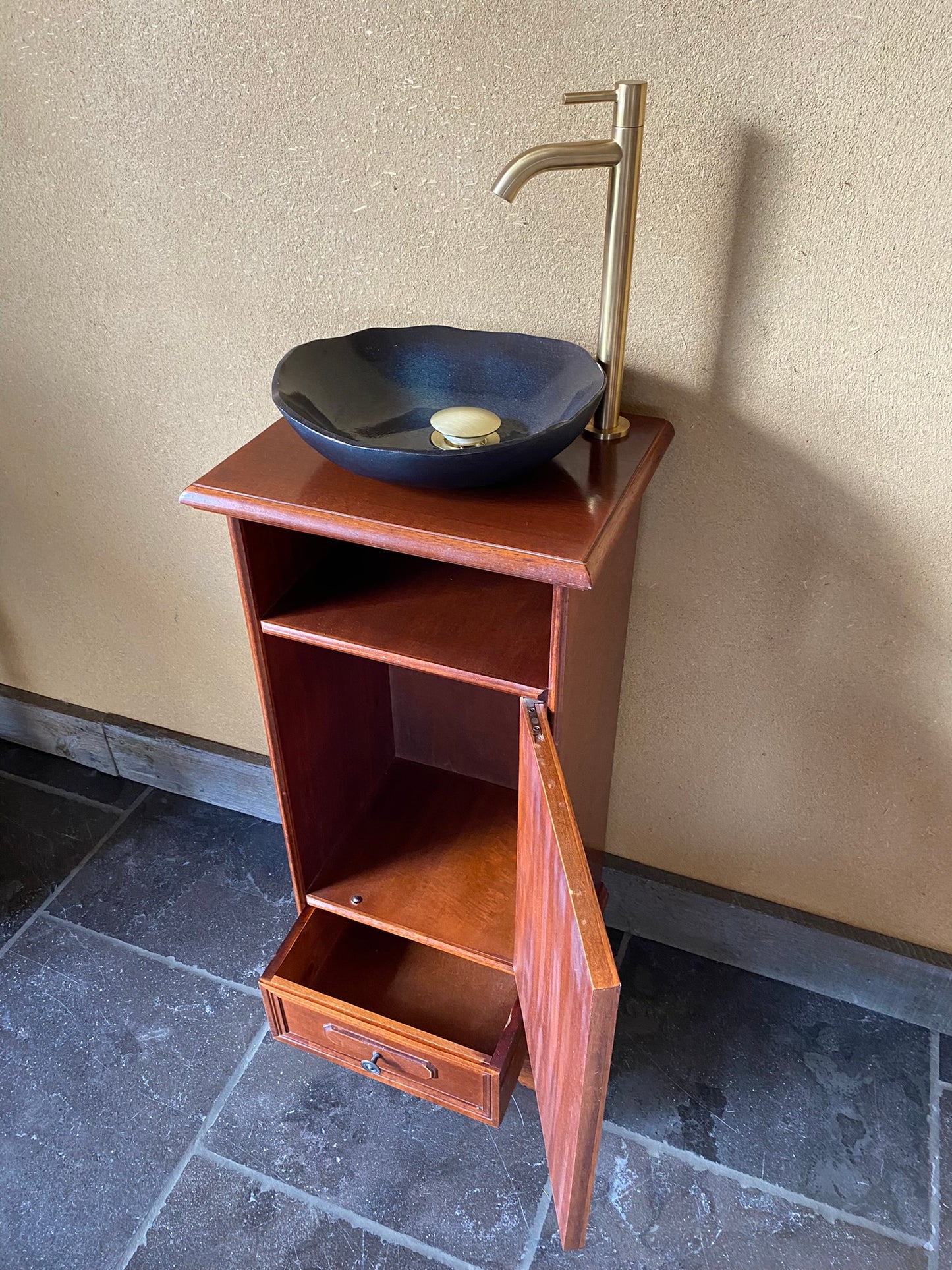 Ambachtelijk sanitair meubeltje met zwarte keramische spoelbak en elegant kraantje
