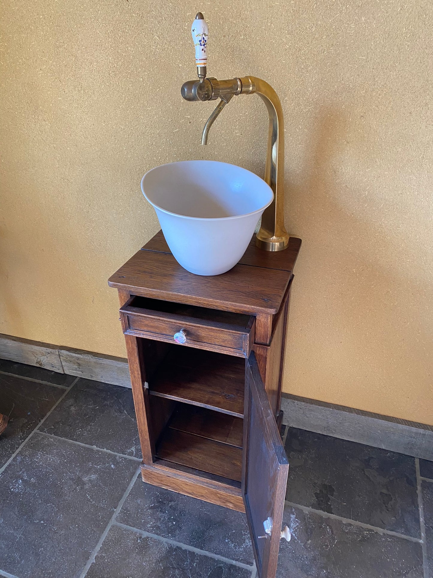 Vintage sanitair meubeltje met witte keramische spoelbak en een originele tapkraan