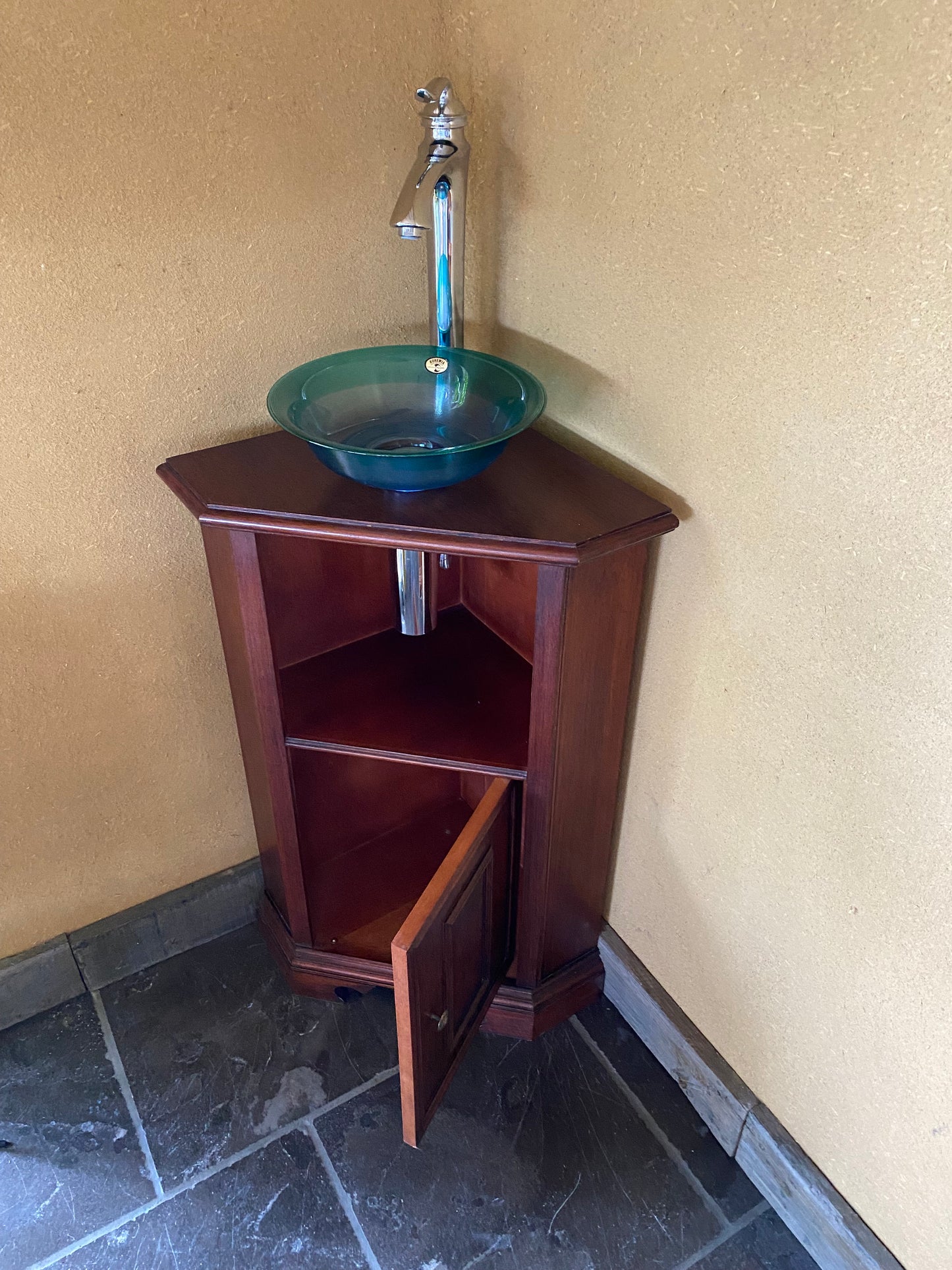 Ambachtelijk sanitair hoekmeubeltje met groen glazen wasbak en kwalitatieve kraan.