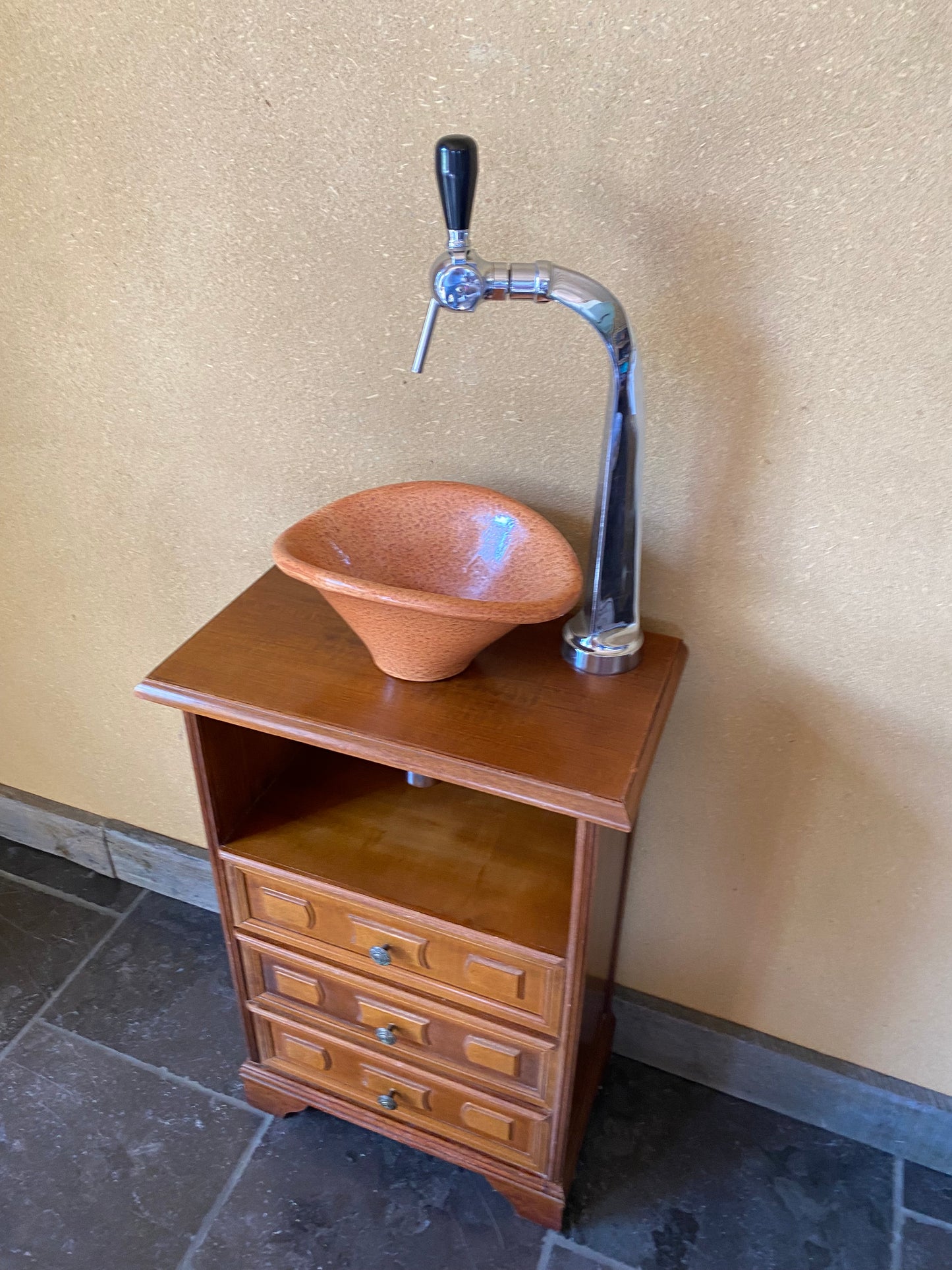 Vintage sanitair meubeltje met originele oranje wasbak en oude tapkraan.