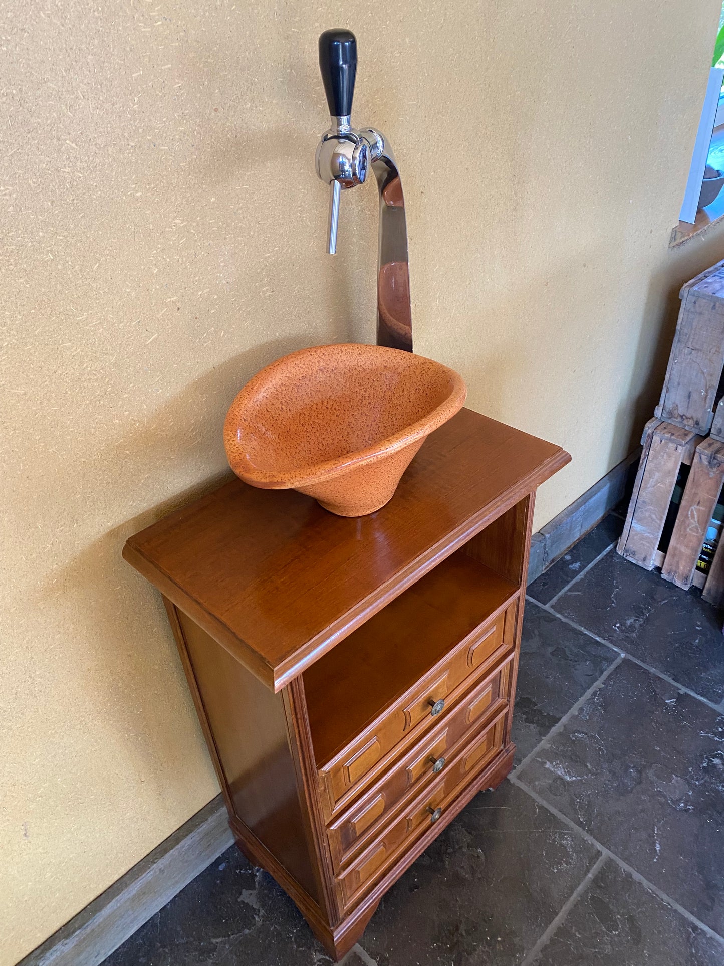 Vintage sanitair meubeltje met originele oranje wasbak en oude tapkraan.