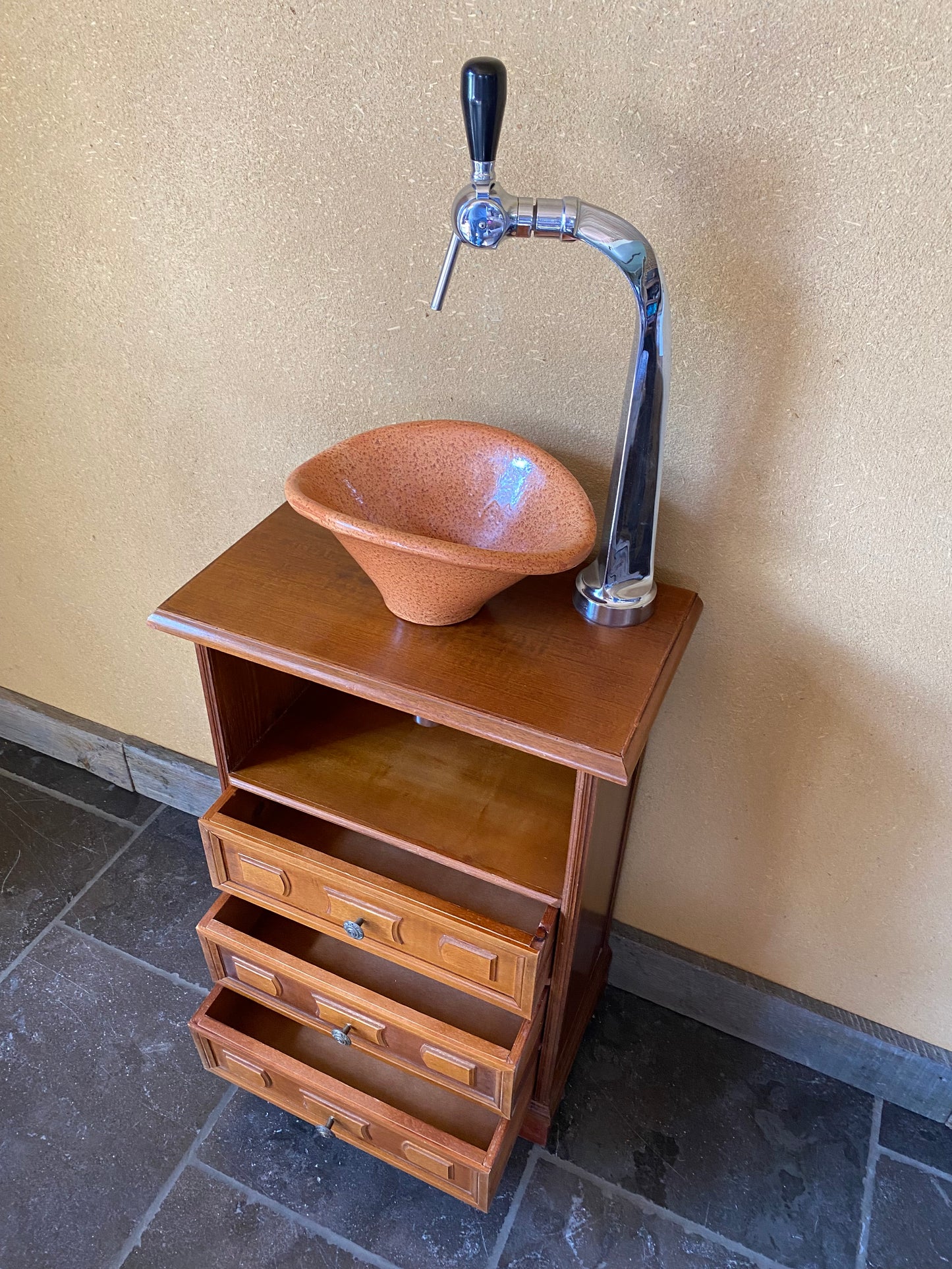 Vintage sanitair meubeltje met originele oranje wasbak en oude tapkraan.